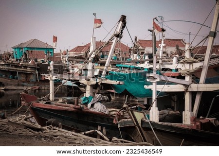 Fishermen's wooden boats lined up on the shore with residential residents in the background