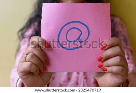 An Indian woman holding email picture icon in hand. Stop spam concept. Selective focus on hands and paper.