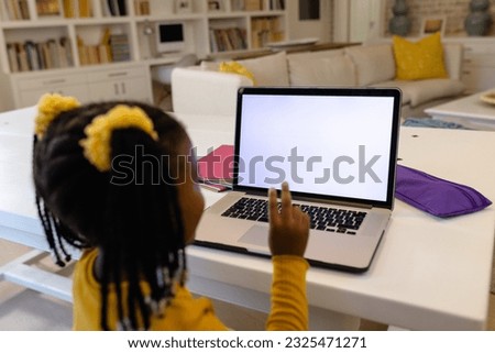 African american girl gesturing while attending online class over laptop on table at home. Copy space, unaltered, childhood, wireless technology, education, student, question, e-learning, video call.