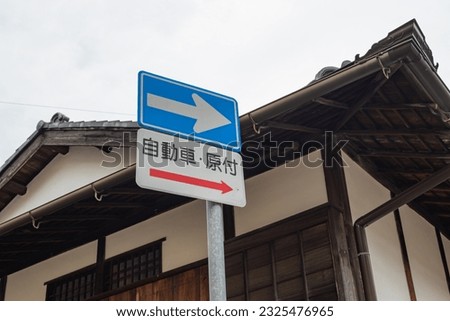 A road sign for "One-Way" on a street corner in Arima Onsen, a famous tourist destination in Japan.The sign is written with kanji characters that mean "automobile" and "moped."
