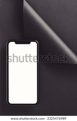 Mobile phone screen mockup, template with clipping path. Phone with blank copy space screen on black folded paper background.