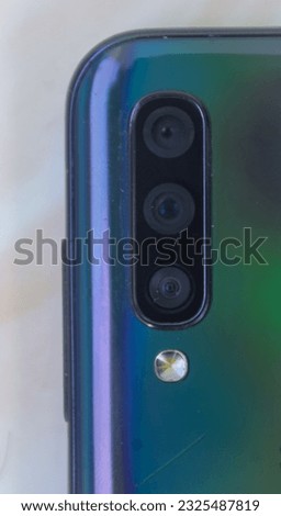 three rear cameras of a brand smartphone with a white background are visible