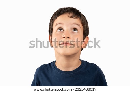 Portrait of a young boy looking up on white background Royalty-Free Stock Photo #2325488019