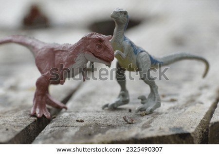 macro photo of fighting dinosaur trex on wooden background