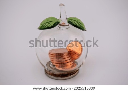 A small glass jar containing Thailand's copper currency coins. It is believed that if brought to worship, it will make good business and wealthy.