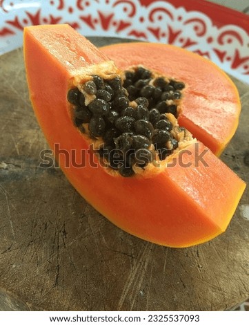 Sliced papaya is placed on a wooden chopping board
