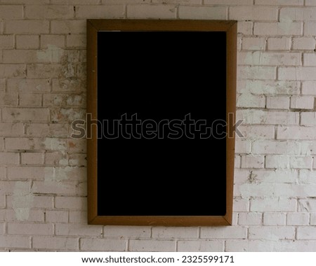 A wooden board hangs on a painted brick wall. Mockup