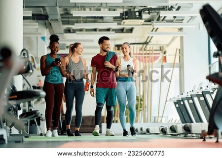 Group of happy friends talking after working out in a gym. Copy space. Royalty-Free Stock Photo #2325600775
