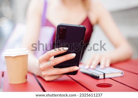 Young woman looking at her schedule and using her cell phone.