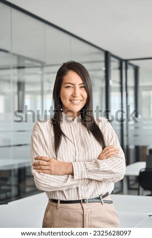 Confident smiling young professional Asian business woman corporate leader, happy japanese female employee, company sales marketing manager, standing arms crossed in office, vertical portrait. Royalty-Free Stock Photo #2325628097