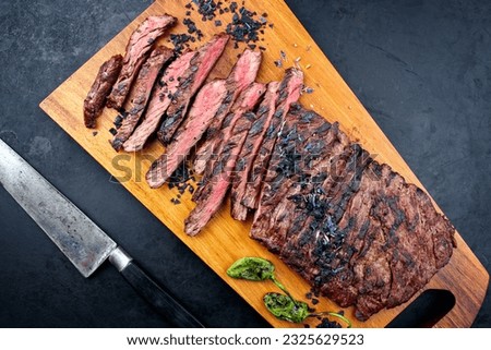 Modern style traditional barbecue wagyu bavette steak with green chili and spices served as top view on a wooden design board  Royalty-Free Stock Photo #2325629523