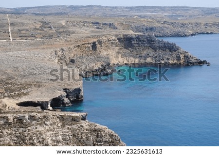 rocky monumental steep coast near the blue ocean without vegetation empty  stone and deserted bright sunny day heat on Malta Royalty-Free Stock Photo #2325631613