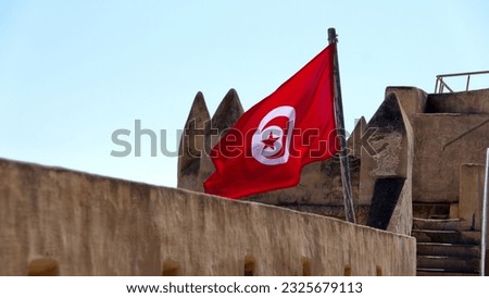 Tunisian flag flying from the wall of the fort, inside the medina, in Hammamet, Tunisia Royalty-Free Stock Photo #2325679113