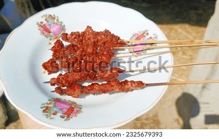 Beef satay with sweet soy sauce and chili sauce on a white plate as a background. a culinary dish that is a favorite because of its popularity which is popular in Indonesia.