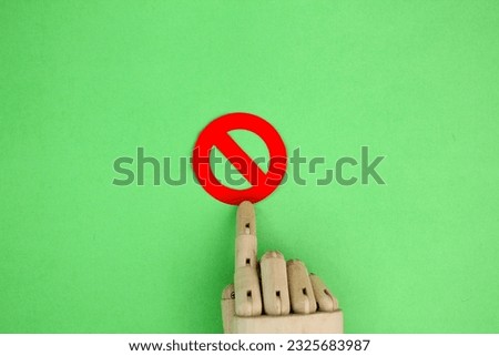 wooden hand with forbidden or not allowed sign. concepts are not allowed or prohibited
