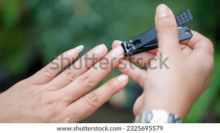 Fingernail clipping, woman cutting nails using nail clippers concept Keeping fingernails clean.