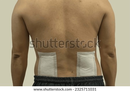 Pain relief patch on men's lumbar region.