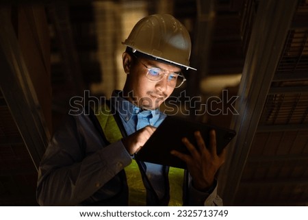 Asian engineer at power station using digital tablet working night shift at petroleum oil refinery in engineering industrial estate Fuel, renewable energy, industrial plants  Royalty-Free Stock Photo #2325713749