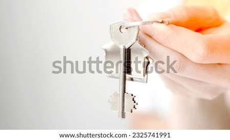the girl holds a keychain with the keys to the apartment. High quality photo
