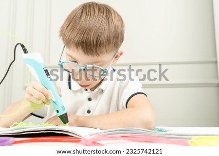 cute boy draws with 3d pen. High quality photo