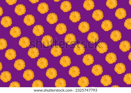 orange pumpkin print top view on purple background small size. High quality photo