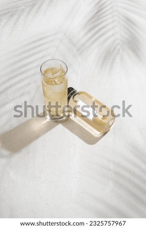 Bottle with juice and white label on tropical white background