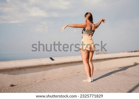 Woman summer dance. Silhouette of a happy woman who dances, spins and raises her hands to the sky. A playful young woman enjoys her happy moment dancing in the rays of the golden sun.
