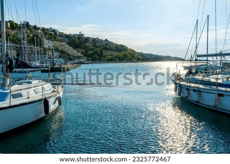 beautiful summer sea landscape of nice boats and yachts in dock with town and green mountains on background