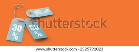 Banner with announcement of discounts. Orange background and three Blue cardboard price tags or labels with percent sign isolated. Discount concept. Material for use in creating graphics, advertising