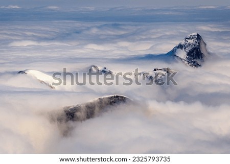 The Grosses Wiesbachhorn and other alpine peaks in High Tauern national park covered in clouds. Royalty-Free Stock Photo #2325793735