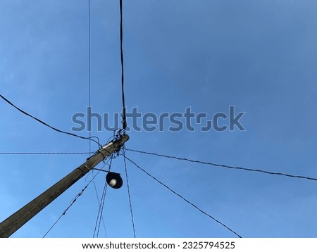 Power line pylons against a blue sky background. Photographed from a low angle.