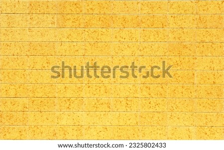 Flat yellow tiles mottled in ocher. Decorative tile socle on the exterior of a house. Background and texture in architecture. Tiles from Spain