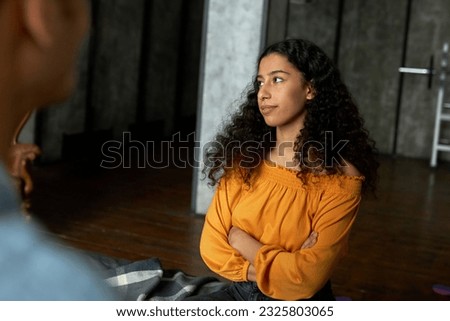 Portrait of youthful pretty african american female sitting on bed with arrogant resentful facial expression listening to his boyfriend and looking aside with annoyance. Selective focus Royalty-Free Stock Photo #2325803065