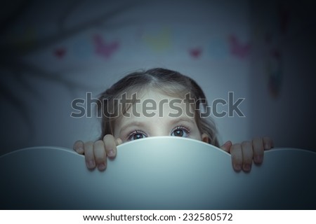 little girl is afraid of shadow of tree Royalty-Free Stock Photo #232580572