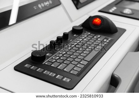 Built-in tabletop input device, industrial keyboard with trackball mouse, modern navigation equipment mounted on a captains bridge  Royalty-Free Stock Photo #2325810933