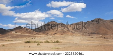 a picture of desert mountains with clouds above. coloured foto. Location in Saudi Arabia