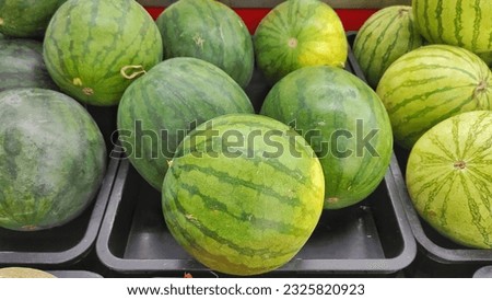 Fresh watermelon fruit on the black plastic displayed rack in supermarket