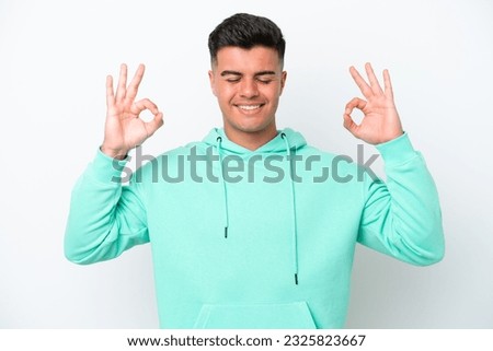 Young caucasian handsome man isolated on white background in zen pose