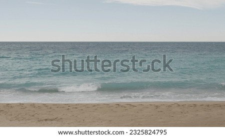 Clear blue waves with strong wind on a sandy empty beach in Cannes in spring