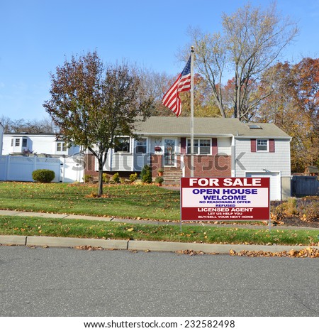 American Flag pole Real Estate For Sale Open House Welcome Sign suburban bungalow home autumn day residential neighborhood blue sky USA
