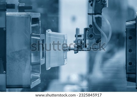 The box container part gripping by  vacuum robotic system from injection process. The food container box production process by automatic system  from plastic injection mold machine. Royalty-Free Stock Photo #2325845917