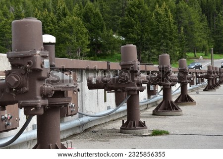 A row of electric AC motors connected to the flood gates a Jackson Lake Dam Royalty-Free Stock Photo #2325856355