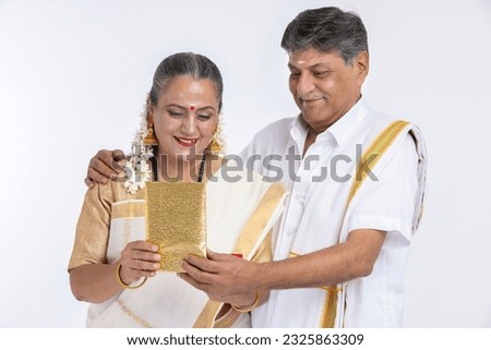 Senior South Indian Couple Celebrating Anniversary, husband Giving Present.