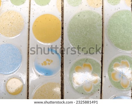 color of plastic bucket and patterns of colorful floor tiles
