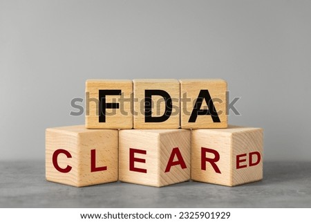 FDA cleared, words on wooden blocks. Beautiful gray background, business concept, Confirmation of inspection and registration of drugs and medical devices used in medicine