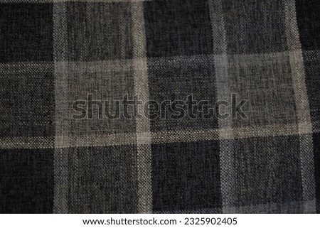 Immerse yourself in the timeless allure of this captivating stock photo featuring a gray plaid fabric background. The intricate pattern and texture of the plaid design exude a sense of classic sophist