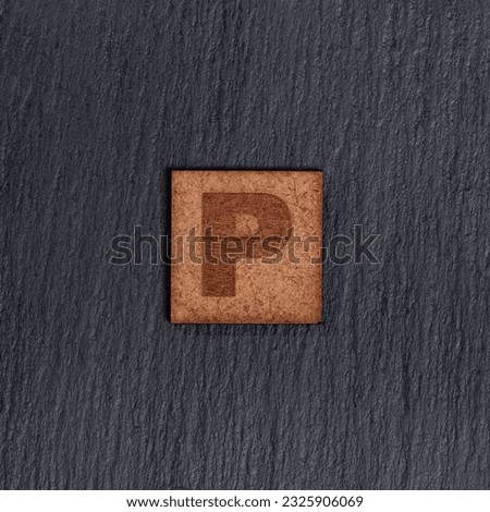Capital Letter In Square Wooden Tiles - Letter P, On Black Stone Background.