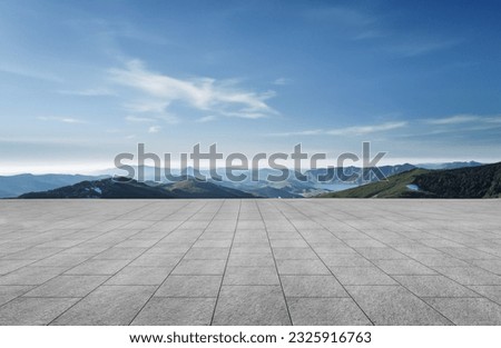 A wide-angle ground with a clear sky and mountainous background for vehicles or products placement Royalty-Free Stock Photo #2325916763
