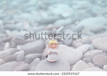 Angel sing a son on pebble stone and gold star for inspiration and background