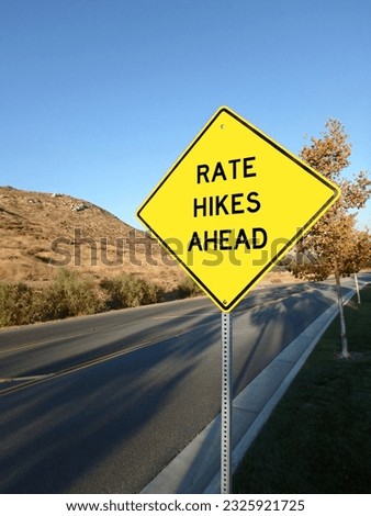 A yellow roadside warning sign warning of interest rate hikes ahead.